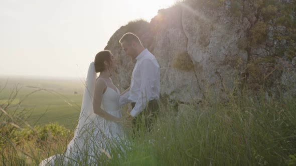 Side View of Young Couple That Smiles and Huggs