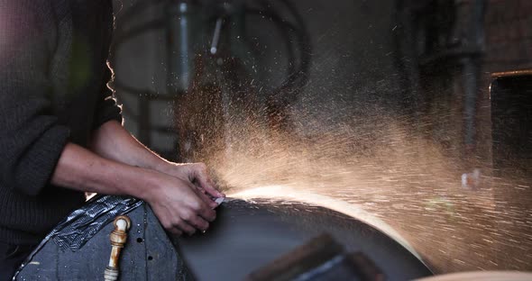 Bladesmith wet grinding a blade