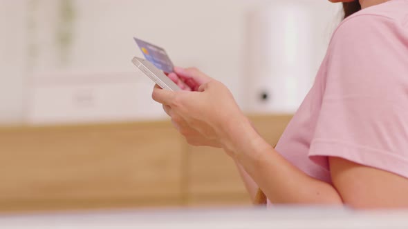 Close up Asian young woman using credit card for pay online shopping on mobile phone