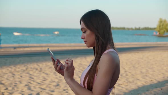 Portrait of Fitness Girl Using Phone on Stadium