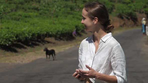 Lady in Shirt Makes Photos of Workers on Tea Plantations