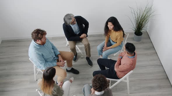 Asian Woman Sharing Difficult Experience During Support Group Meeting Then Doing Highfive with