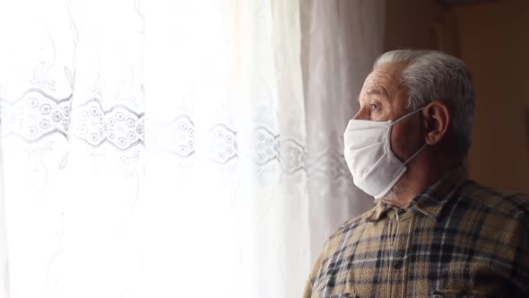 Mature man at home in a surgical face mask. 