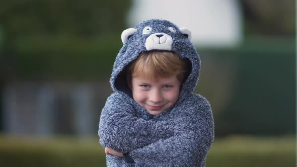 Funny young boy in bear suit has fun on camera alt