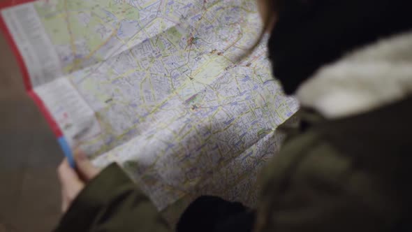 Tourist holding detailed city map of Berlin and looking at it, close up