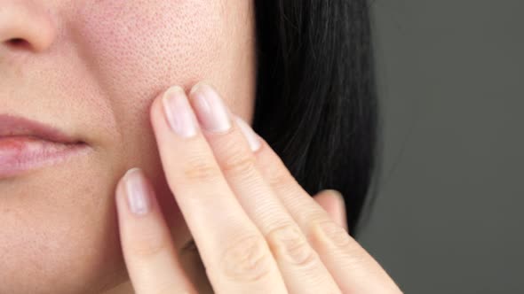 The Girl Examines the Problem Skin with Enlarged Pores Touching Her Face with Her Fingers