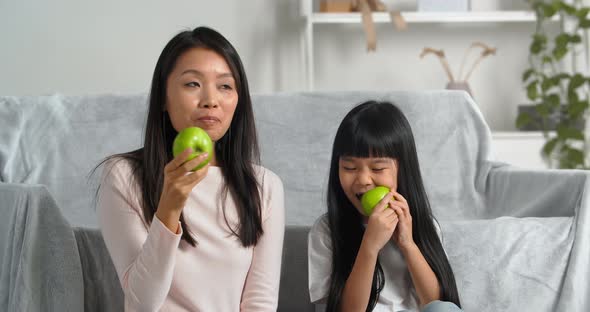 Asian Vegetarian Family Young Mom and Longhaired Girl Child Daughter Sitting Together Eating