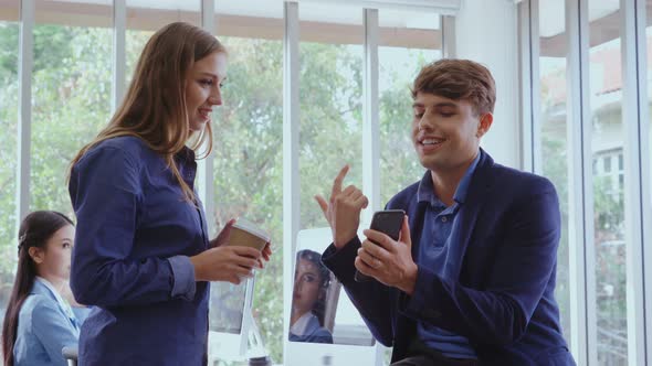 Happy Businesswoman and Businessman Having Conversation in Modern Office