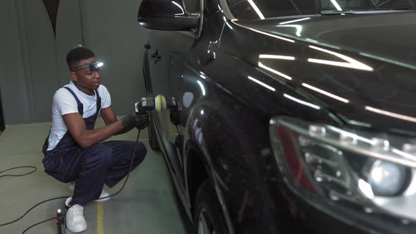 A Young AfricanAmerican Polishes a Car