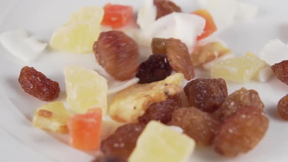 Slices of dried fruit fall to the bottom of a white plate.