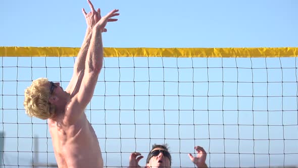 Men playing beach volleyball.