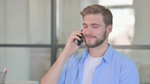 Portrait of Young Creative Man Talking on Smartphone