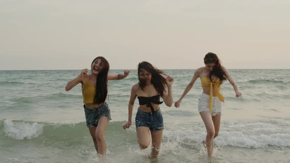 Young friends happy relax having fun playing on beach near sea when sunset in evening