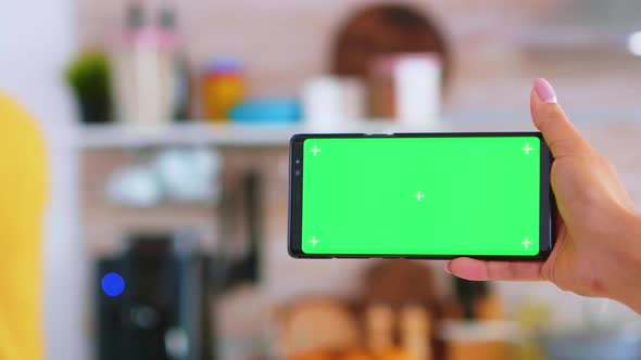 Woman Hand Holding Smartphone with Green Screen