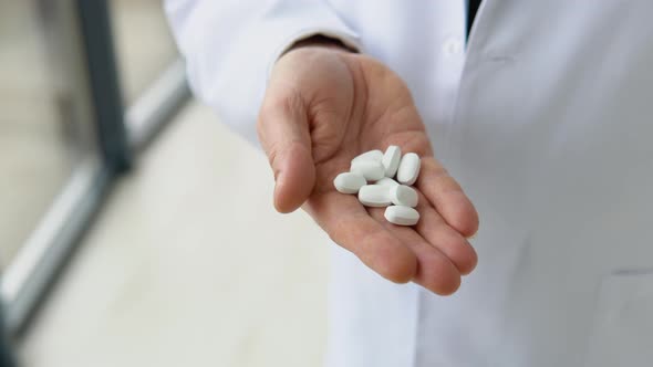 Senior Doctor Holds Pills in Hand