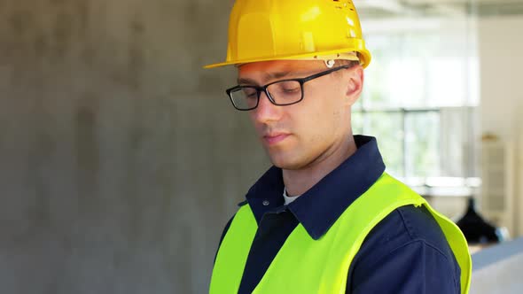 Builder in Helmet and Safety West with Tablet Pc