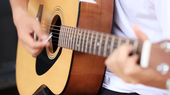 Close up of hand playing acoustic guitar