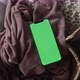Modern smartphone laying on cozy grey blanket at home with green screen chromakey - VideoHive Item for Sale
