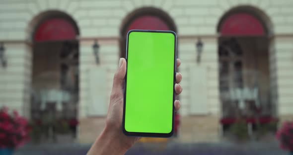 Close Up View of Female Hand Holding Smartphone with Mockup Blank Screen. Concept of Green Screen