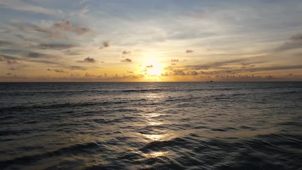 Drone shots flying forward to dramatic sea sunrise.