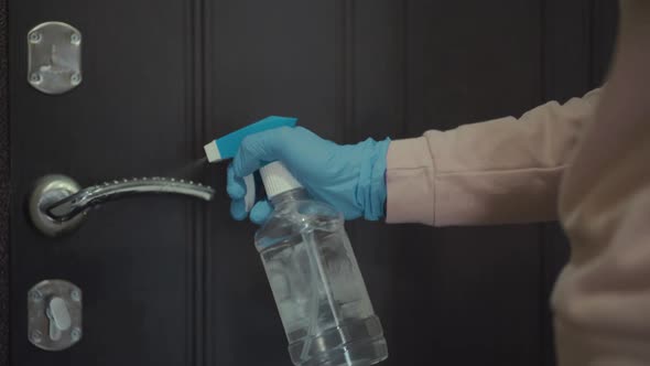 Closeup of Woman Hands Using a Sanitizer and a Wet Towel for Disinfection Doors Knob