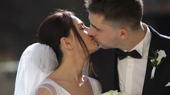 Close Up of a Young Married Couple Kissing They are Beautifully Lit By the Sun