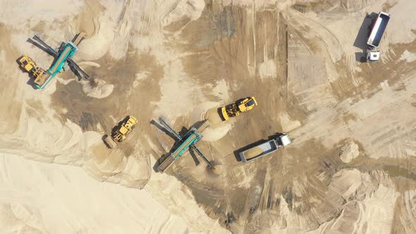 Aerial view, machinery working at clay quarry, heavy loaders, large trucks, bulldozers, excavators,