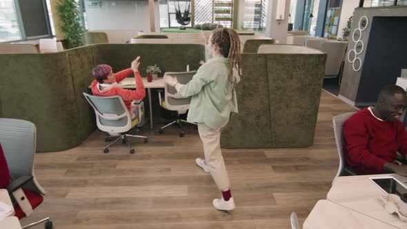 Young Businesswoman High-Fiving Colleagues