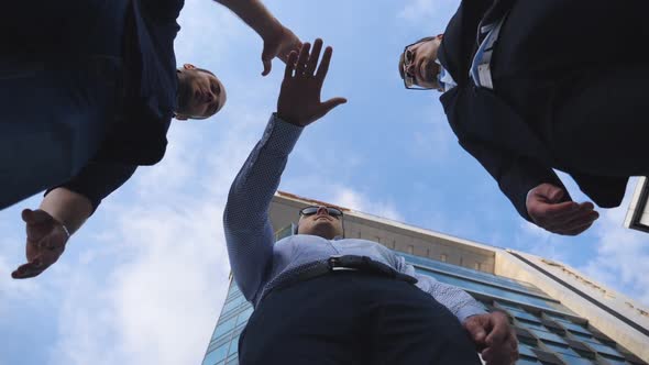 Successful Businessmen Standing and Stacked Hands Together Near Office Building. Male Colleagues