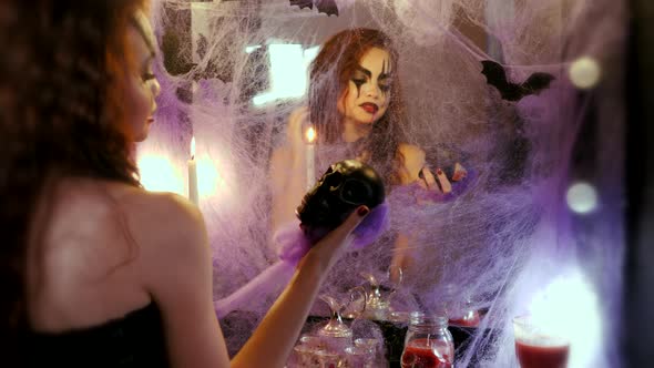 Maquillage of the Actor, the Bride of the Devil. Girl with Halloween Makeup Blows Out a Burning