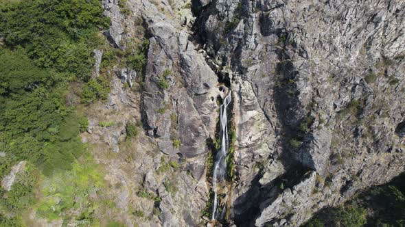 Spectacular waterfall from rocky cliff in Portugal, aerial drone moving shot