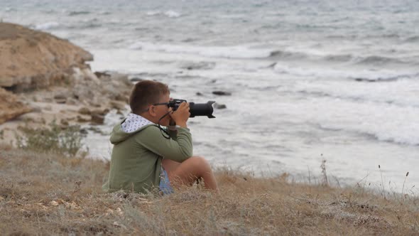 Beach Summer Vacation. Boy on the Beach with a Camera.