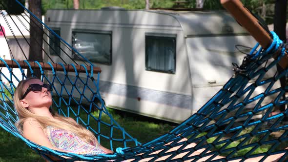 Young beautiful woman enjoying and relaxing in a hammock in the woods.