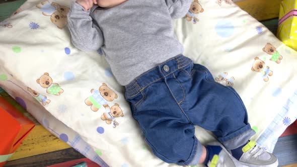 Baby Lying Near Presents.