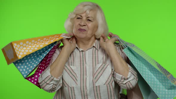 Senior Grandmother Raising Shopping Bags, Celebrating, Satisfied with Purchase, Discount. Chroma Key