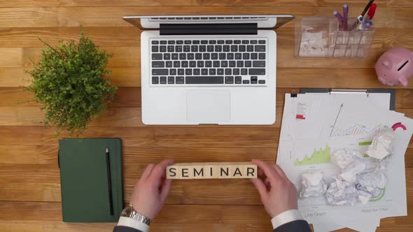 Word Seminar is Collected From Wooden Cubes with Letters with Hands on the Office Table