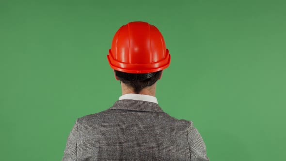 Rear View Shot of a Businessman Putting on Protective Hardhat