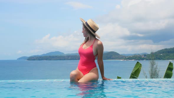 Outdoor Vacation of Young Pretty Sexy Woman in Swimsuit Sitting in Swimming Pool