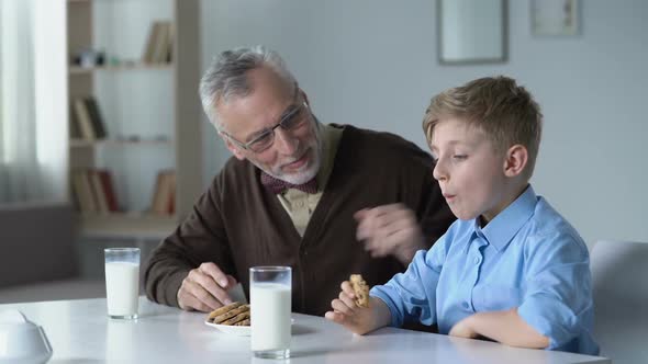 Boy Eating Cookies With Milk, Sharing With Grandfather News From Kindergarten