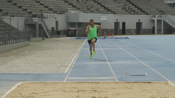 Front view of caucasian athlete doing long jump