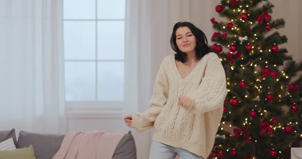 Funny Dancing Woman Celebrating New Year Near Christmas Tree at Home