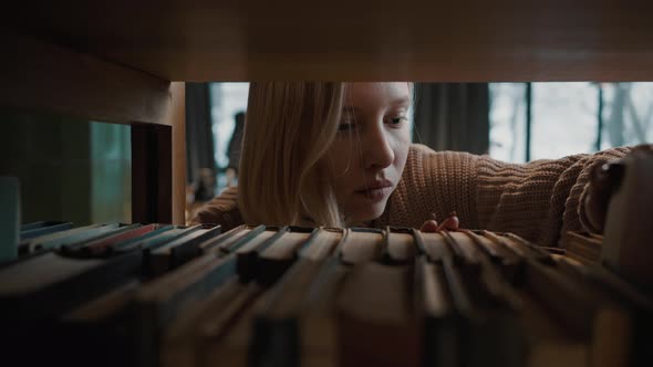 Shot Inside of Bookshelf of Young Focused Woman Student Searching Book at Library Tracking Shot Slow