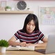Portrait of Asian schoolgirl studying online reading a textbook - VideoHive Item for Sale