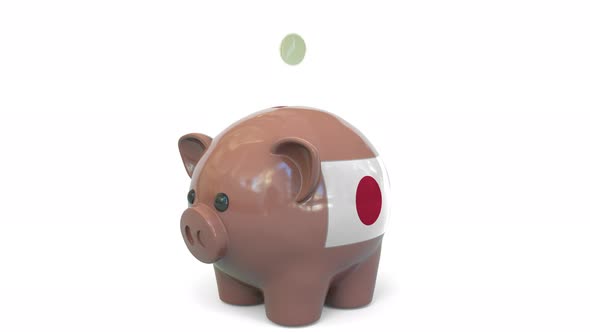 Putting Money Into Piggy Bank with Flag of Japan