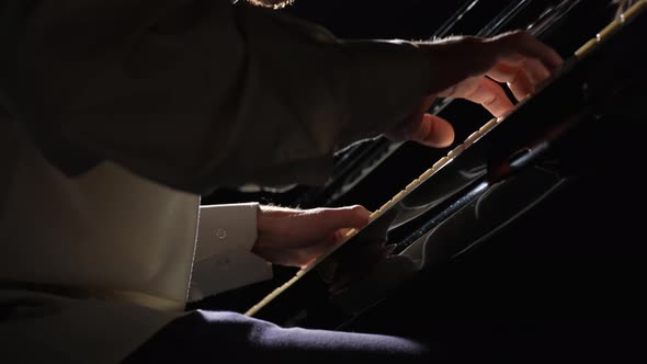 Low Angle View of Man Playing Piano on Black Background