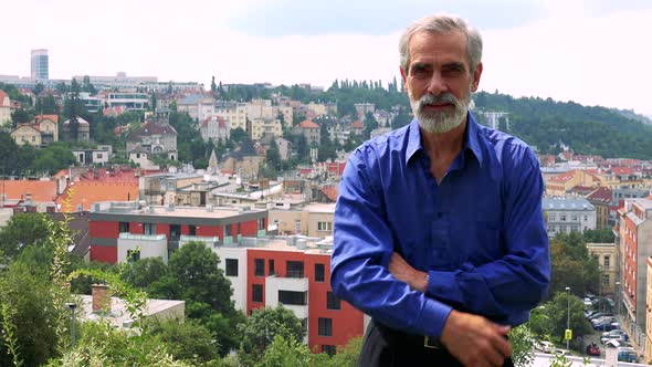 Old Senior Man Shows Thumb Up on Agreement - City (Buildings) in Background