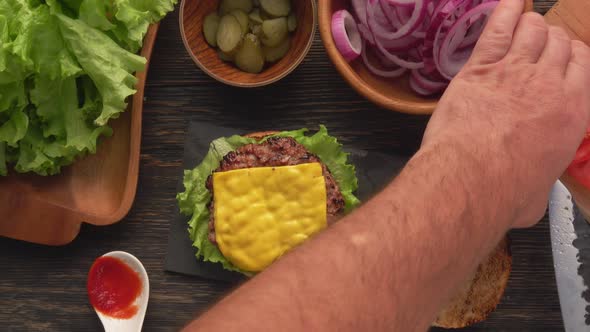 Top View of the Male Hands Making a Delicious Homemade Grilled Burger