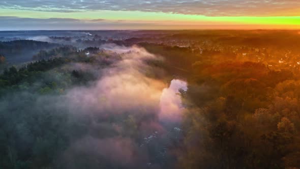 Foggy sunrise at river in autumn at sunrise, aerial view