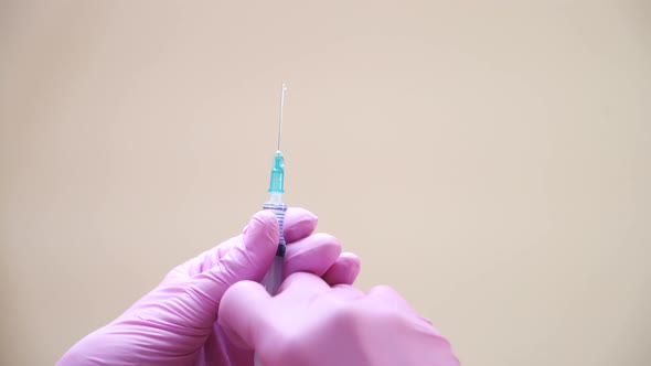 Cosmetologists Hands in Gloves Holding Syringe 