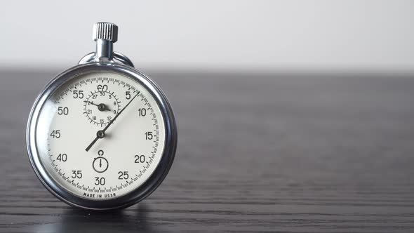 Stopwatch on a dark wooden table. Time measurement tool